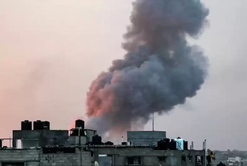 Asap mengepul di atas gedung-gedung selama serangan udara Israel di kota Rafah, Jalur Gaza selatan pada 11 Mei 2023.
