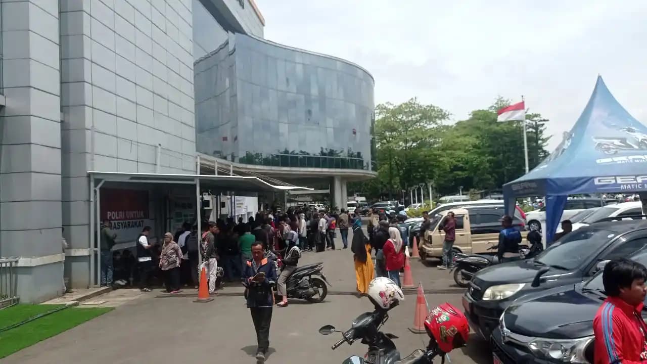 Caption:  Suasana antrean wajib pajak di depan gudang arsip kendaraan roda dua kantor Samsat Soekarno Hatta