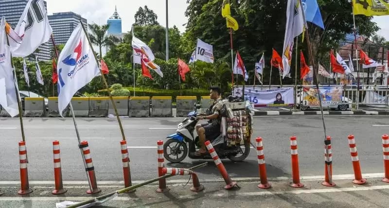 Alat peraga kampanye (APK) pemilu 2024 yang terpasang di pembatas jalur sepeda (stick cone) di kawasan Menteng, Jakarta