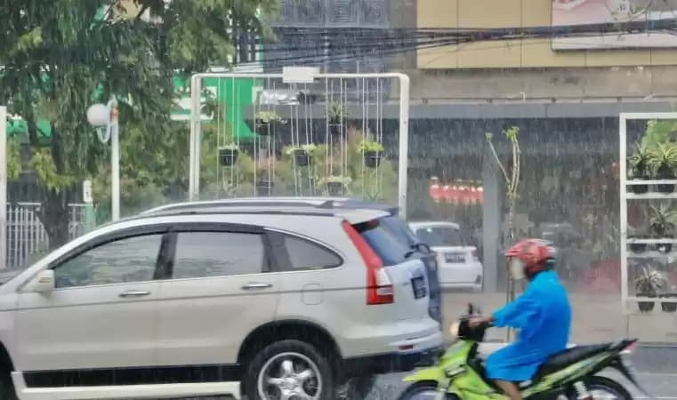 Foto Pengendara melintas di tengah guyuran hujan deras