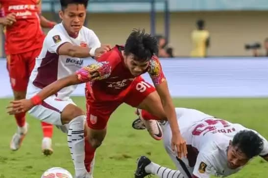 Foto Pesepak bola Persis Solo Rendy Sanjaya berebut bola dengan PSM Makassar