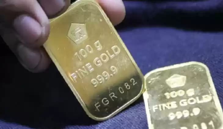 Foto  Pramuniaga menunjukkan emas batangan Aneka Tambang