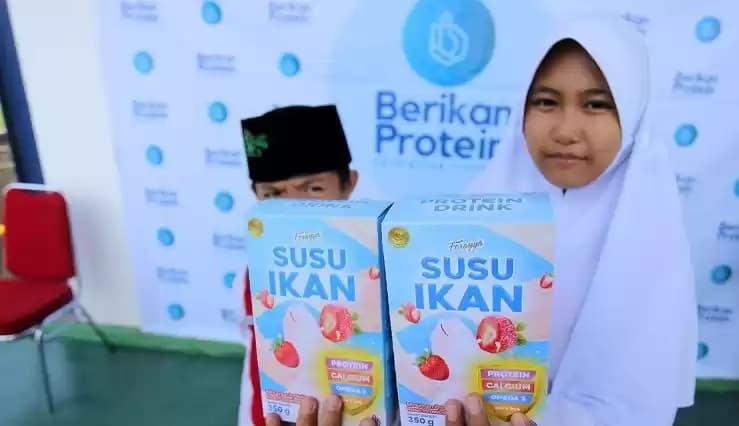 Ilustrasi - Dua orang anak menunjukkan produk susu ikan