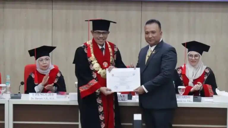 M. Edi Faryadi menerima dokumen kelulusan dari Ketua Sidang Promosi Doktor Ilmu Hukum Universitas Jambi