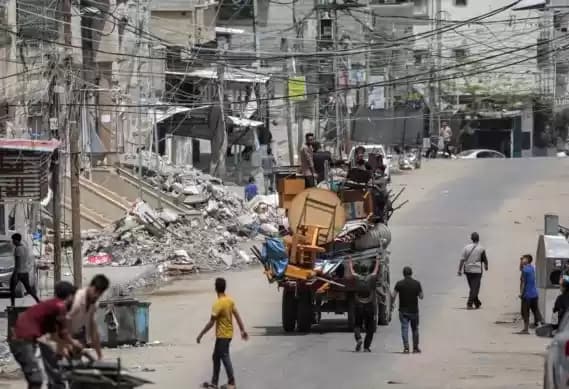 Para pria duduk di belakang truk yang memuat perabotan dan barang-barang lainnya saat mereka melarikan diri menuju Khan Yunis, di Rafah di selatan Jalur Gaza pada 11 Mei 2024. (Foto: AFP)