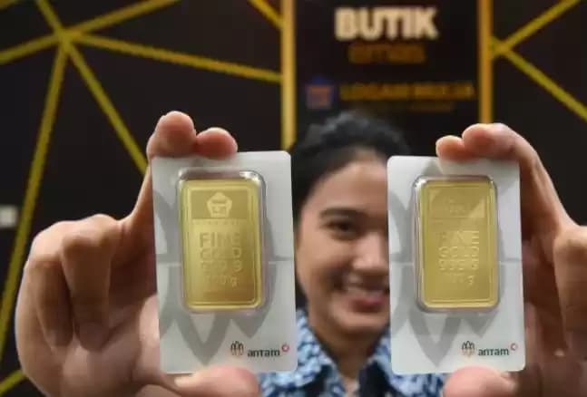 Pegawai menunjukkan emas Antam