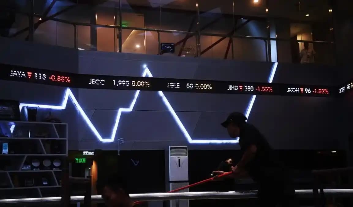 Pekerja melintasi layar digital pergerakan saham di Bursa Efek Indonesia,