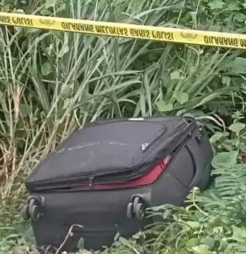 Penampakan koper berwarna hitam yang diduga berisi mayat di semak-semak di kawasan Cikarang, Bekasi, Jawa Barat.