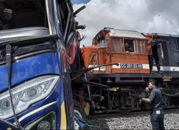 Petugas berusaha mengevakuasi bus penumpang Putra Sulung yang tertabrak Kereta Api