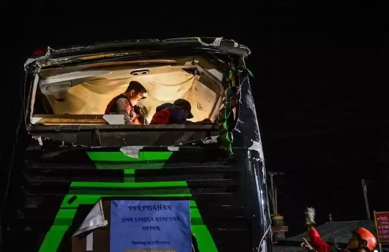 Petugas kepolisian mengevakuasi korban kecelakaan bus pariwisata