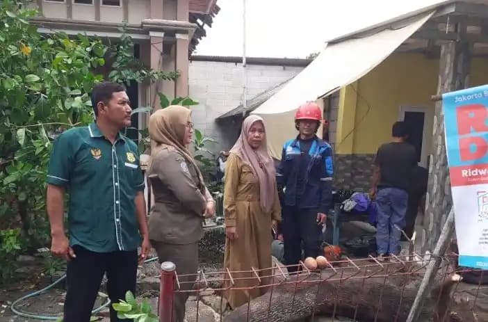 Petugas membersihkan puing bangunan yang terdampak angin puting beliung