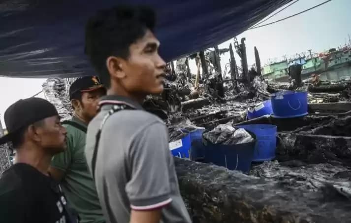 Sejumlah pekerja melihat bangkai kapal yang hangus terbakar