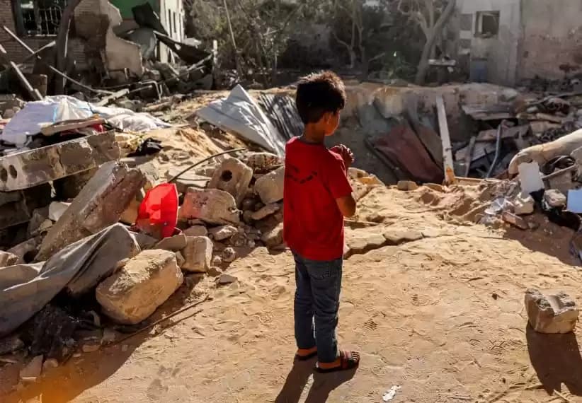 Seorang bocah laki-laki berdiri di depan reruntuhan bangunan yang dihantam oleh serangan Israel di Rafah, di bagian selatan Jalur Gaza pada 8 Mei 2024. (Foto: AFP)