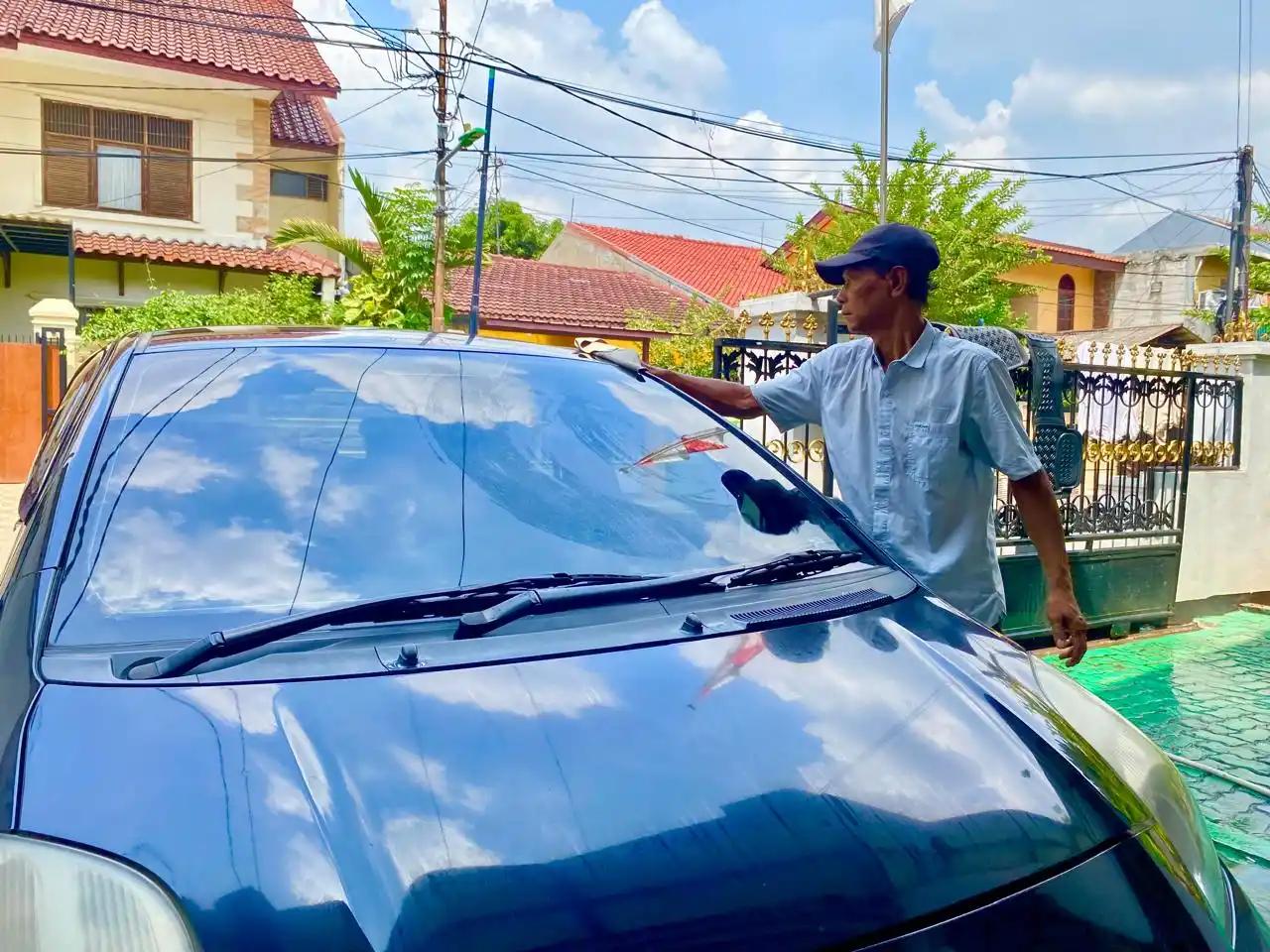 Seorang sedang mencuci mobil