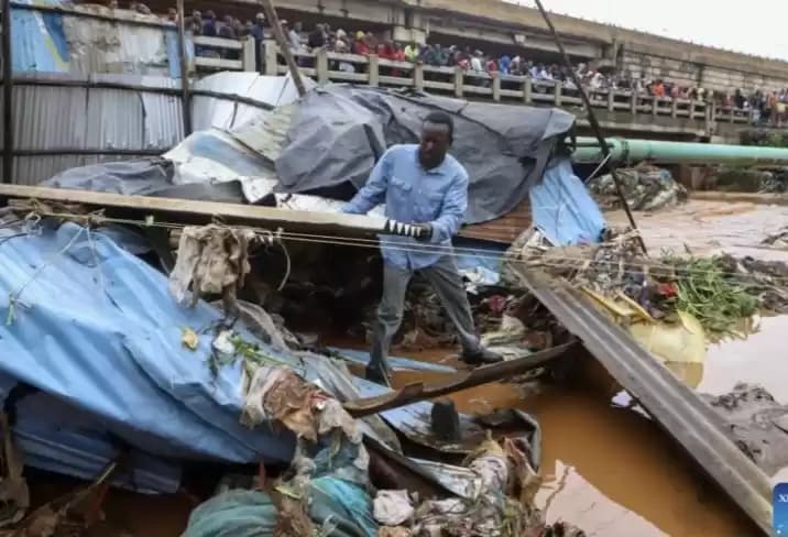 Seorang warga menyelamatkan barang sisa banjir