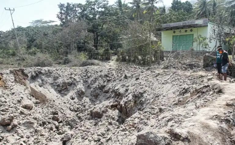 Warga melihat sisa material erupsi Gunung Lewotobi Laki-laki di Desa Klatanlo