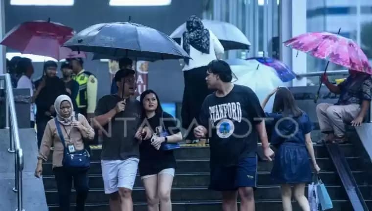 Warga menggunakan Payung di kawasan Stasiun MRT Sudirman